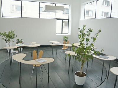 Blick in die Ausstellung – Galerieebene mit Tischkombinationen "Bordeaux 2" von SANAA